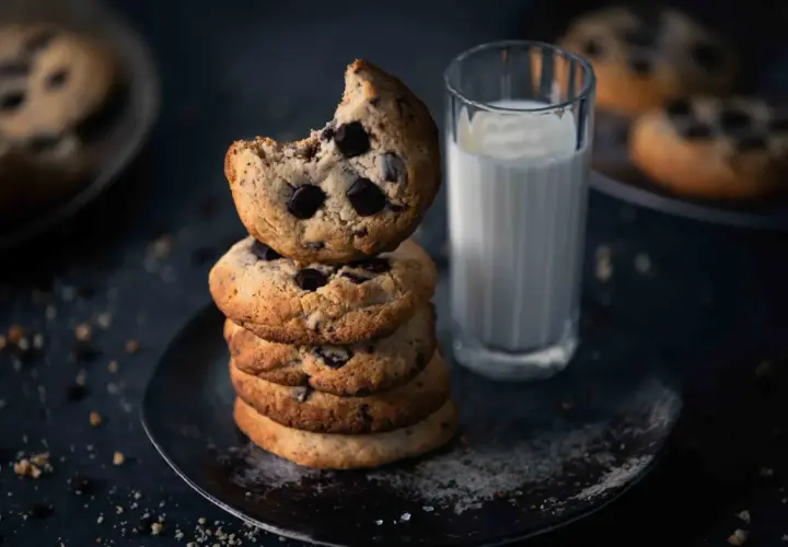 Ein Stapel weicher Chocolate Chip Cookies, perfekt für ein Cookies Rezept. Daneben ein Glas Milch.
