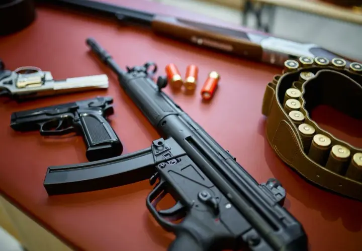 Na stole leżą pistolety, karabin i pas z amunicją. To wszystko może być częścią pozwolenia na broń obiektową.