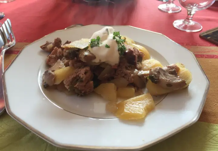 Un plat de baeckeoffe fumant, garni de crème et de persil. Quel vin avec baeckeoffe ? Un Riesling d'Alsace serait parfait.