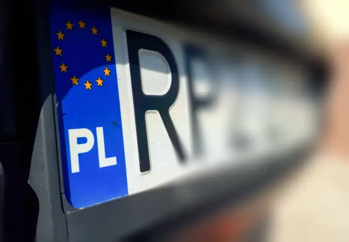 Zbliżenie na polską tablicę rejestracyjną z symbolem UE. Litery "PL" i fragment numeru wskazują na rni rejestracja.