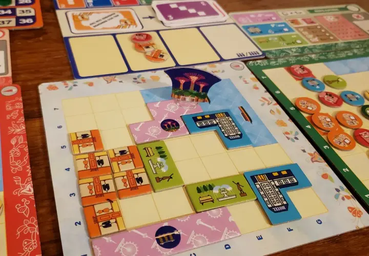 Bunte Spielbretter und Plättchen für deutsche Brettspiele. Mehrere Spieler legen ihre Züge auf dem Spielfeld ab.