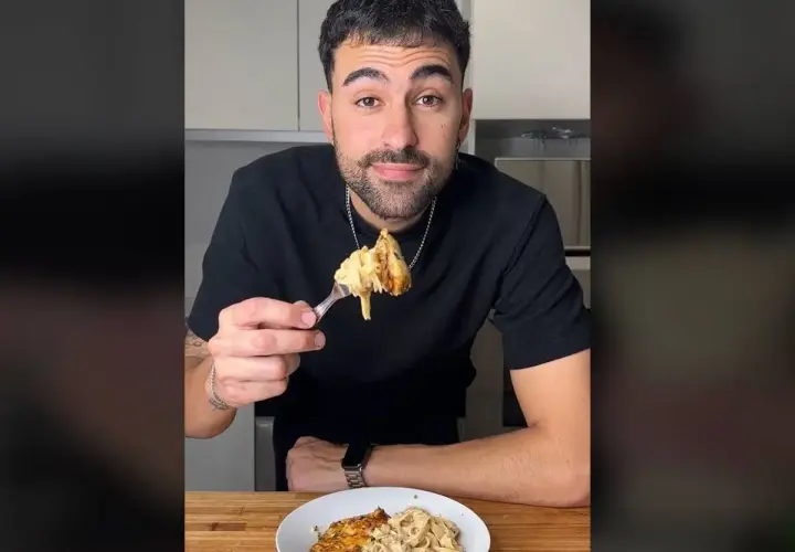Hombre sonriendo mientras prueba unos deliciosos macarrones con pollo.