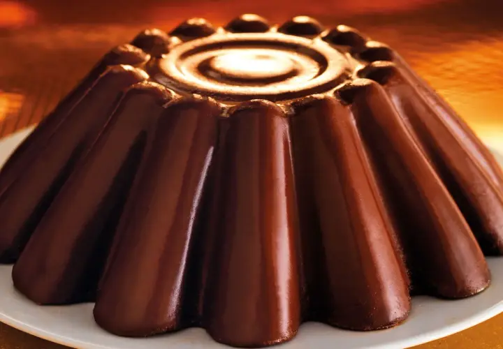 Budino al cioccolato lucido e invitante, con un disegno a spirale al centro e una forma a petali che promette un sapore intenso.