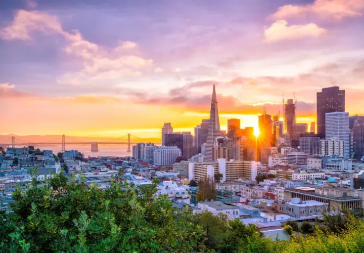 Widok na San Francisco o zachodzie słońca z mostem Golden Gate w tle.