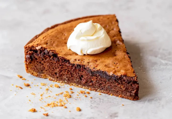 En bit kladdig protein kladdkaka med en klick vispad grädde.