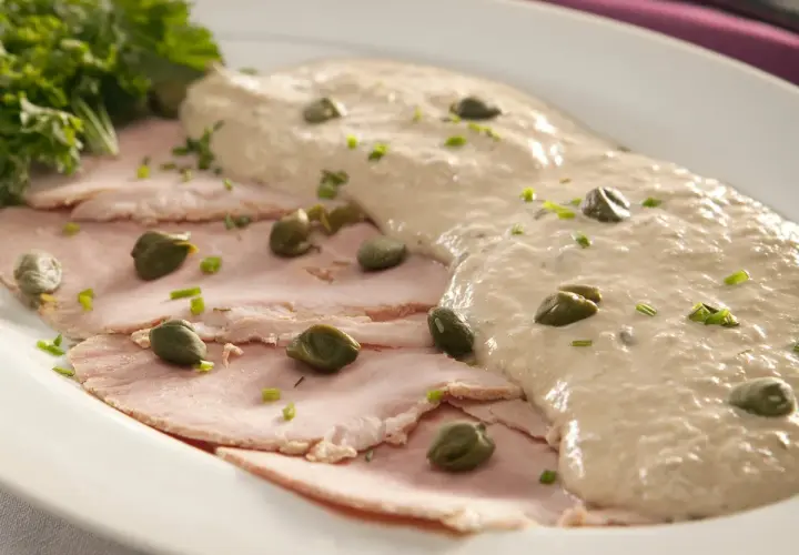 Fette sottili di carne rosa, guarnite con capperi e salsa cremosa, un classico vitel tonnè, origine piemontese.