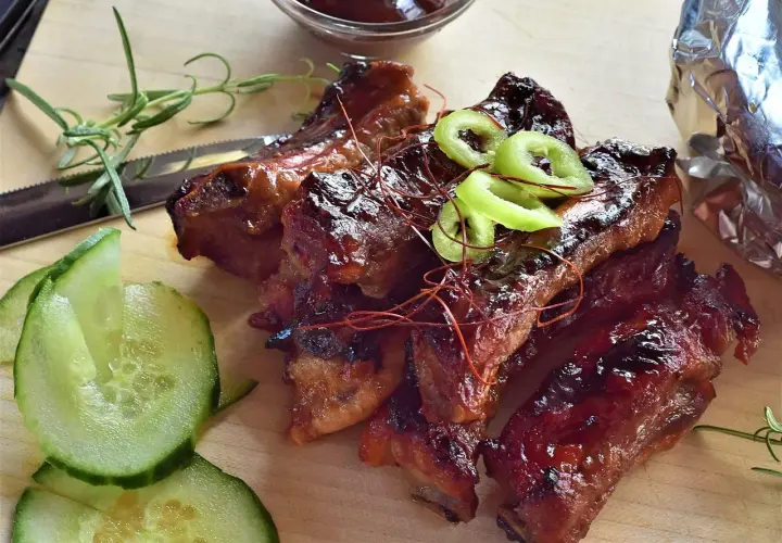 Délicieux ribs barbecue, prêts à déguster. Le temps de cuisson parfait pour des ribs tendres et savoureux. Accompagnés de concombre frais et de romarin.