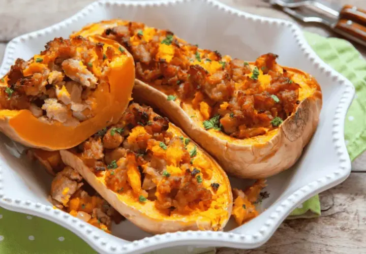 Courges butternut farcies à la saucisse, cuites à l'air fryer, garnies de persil frais, servies dans un plat blanc.