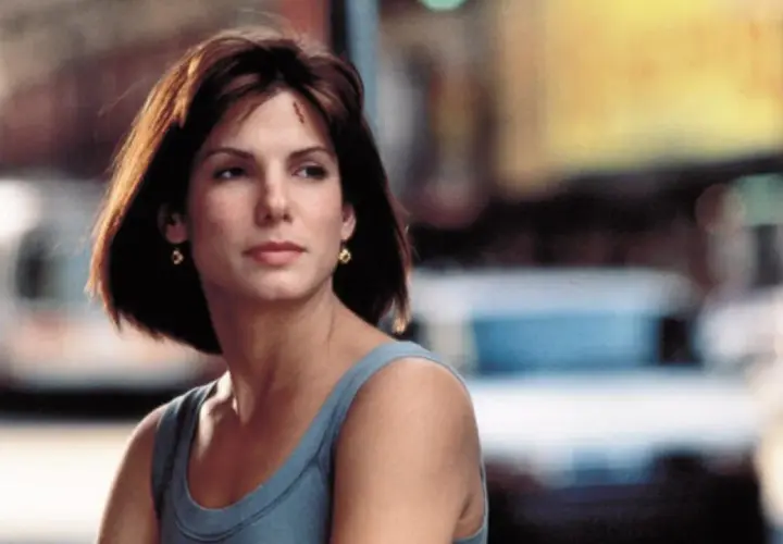 Sandra Bullock w niebieskiej sukience, zastanawia się, ile ma lat.