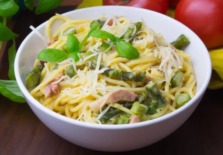 Pyszna carbonara ze szparagami, udekorowana bazylią i parmezanem. Idealna na wiosenny obiad.