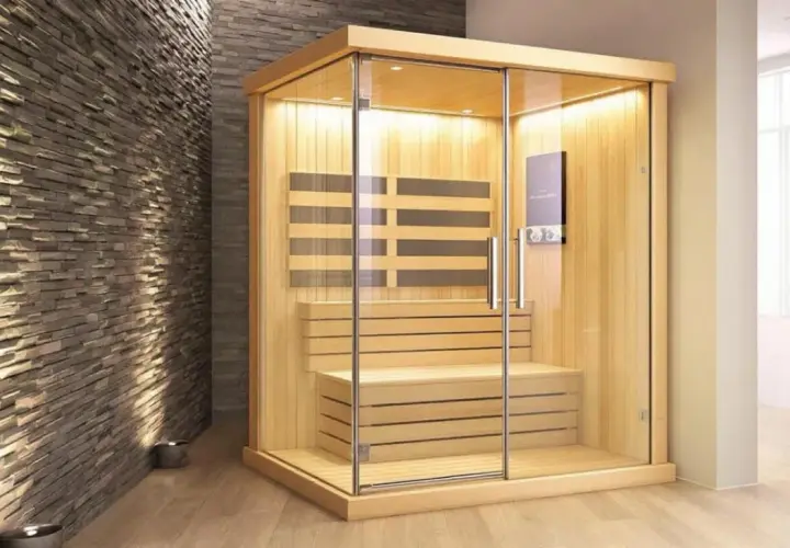 Une cabine de sauna moderne en bois et verre, idéale pour se détendre. Combien de sauna par semaine pour un bien-être optimal ?