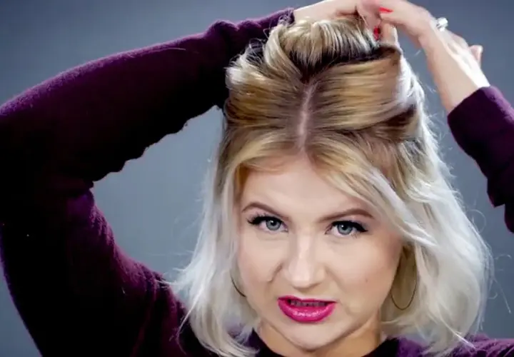 Mujer con pelo rubio corto haciendo un semirecogido con las manos.