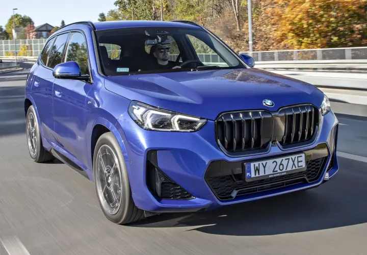 Niebieskie BMW X1 w ruchu drogowym. Sprawdź aktualną bmw x1 cena i ofertę.