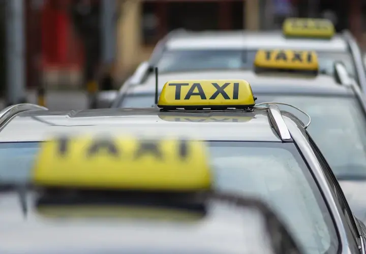 Rząd żółtych taksówek z napisem "TAXI" na dachach.