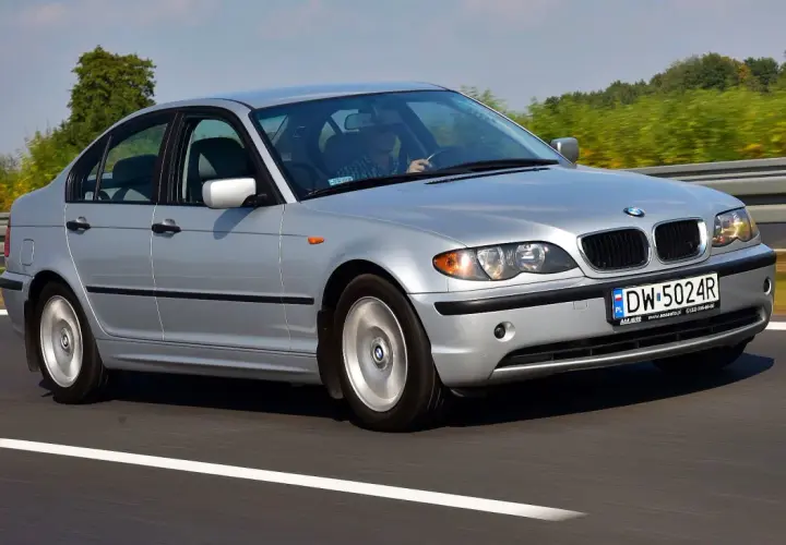 Srebrne BMW E46 330i jedzie po autostradzie, za kierownicą siedzi mężczyzna.