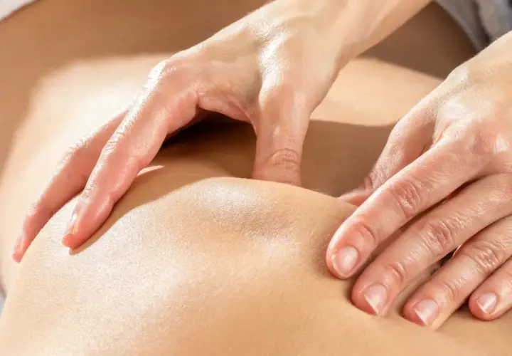 Mains expertes prodiguant un massage kinésithérapique apaisant, soulageant les tensions musculaires.