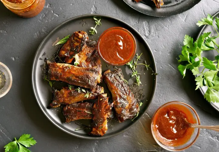 Soczyste żeberka pieczone na patelni, polane sosem BBQ. Aromatyczne zioła i świeża natka pietruszki dopełniają danie.
