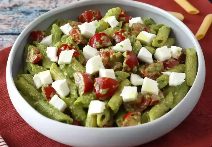 Penne z zielonym pesto, pomidorkami koktajlowymi i kostkami mozzarelli. Idealna sałatka z rukolą na letni obiad.