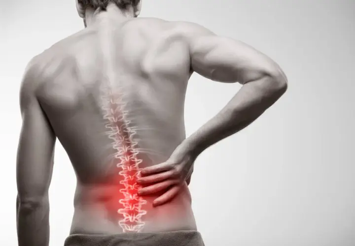 Mężczyzna odczuwa ból w dolnej części pleców, gdzie widoczne jest zapalenie mięśni kręgosłupa.