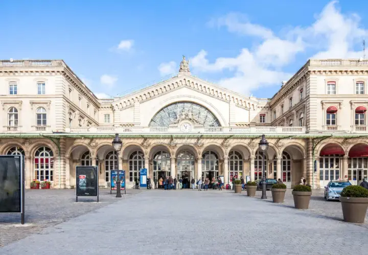 Prachtvoller Bahnhof in Paris Zentrum mit Bögen und einer großen Uhr.