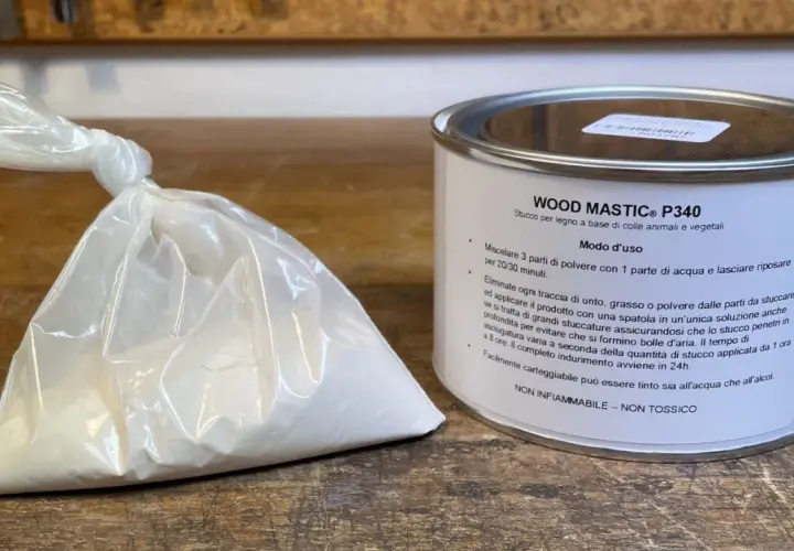 Sacchetto di stucco in polvere e barattolo di stucco per legno. Istruzioni su come si prepara lo stucco in polvere: mescolare 3 parti di polvere con 1 parte d'acqua.