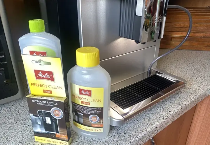 Płyn i tabletki Melitta Perfect Clean obok ekspresu. Idealne, by dowiedzieć się, jak odkamienić ekspres Dolce Gusto.