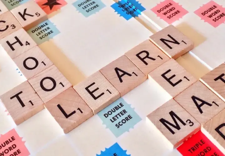 Litery na planszy do gry układają się w słowa "SCHOOL", "LEARN", "MATH". Czy angielski jest trudny? Zależy od tego, jak się uczysz!