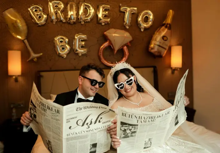 Para młoda czyta gazetę "The Wedding Post" z nagłówkami "Miłość", "Wielki dzień nadszedł!" i "Wszystkie przygotowania zakończone!". To ich przykładowy harmonogram wesela.