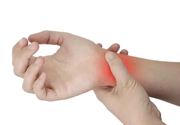 Una mano se presiona la muñeca, donde un área roja indica dolor por tendinitis.