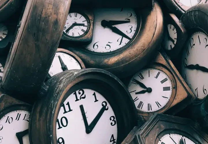 Montón de relojes antiguos, algunos con números romanos. El 0505 significado espiritual nos invita a reflexionar sobre el tiempo.