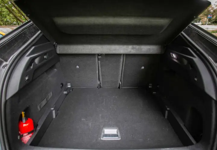 Pusta przestrzeń bagażowa Peugeot 3008, z widocznym gaśnicą. Wymiary bagażnika pozwalają na przewóz wielu rzeczy.