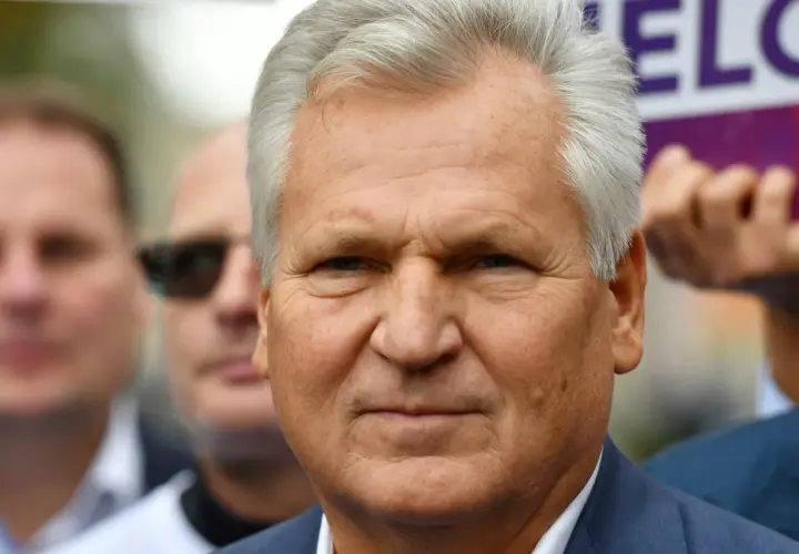 Aleksander Kwaśniewski, były prezydent, w otoczeniu ludzi. Jego prezydentura to ważny rozdział w historii Polski.