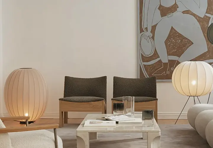 Un salón moderno con dos lámparas de pie grandes, una rosa y otra blanca, iluminando el espacio.