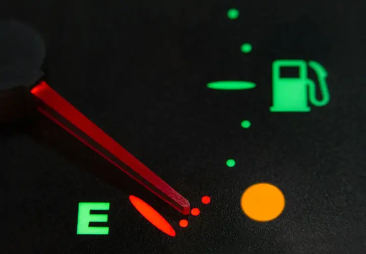 Indicador de combustible casi vacío, con la aguja roja apuntando a la 'E'. La luz de reserva está encendida. Así sabrás como saber si la llave del gas está abierta.