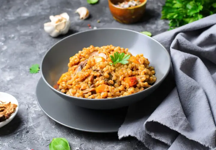 Insalata di farro con funghi e verdure, guarnita con prezzemolo fresco. Un piatto gustoso e salutare.