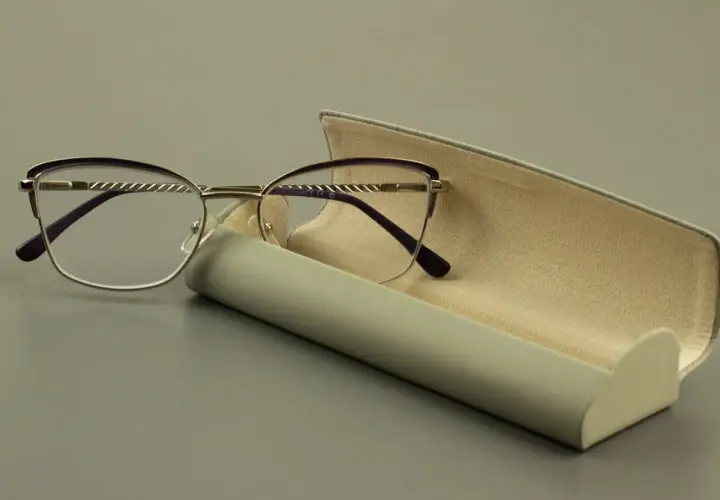 Eleganckie okulary z soczewką asferyczną i fioletowymi oprawkami, obok otwartego etui.