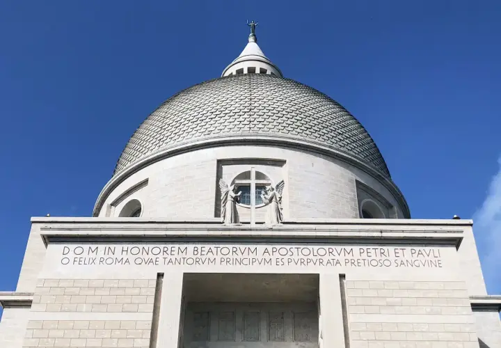 Cupola imponente di San Pietro e Paolo a Roma, con iscrizione latina che celebra la città e gli apostoli.