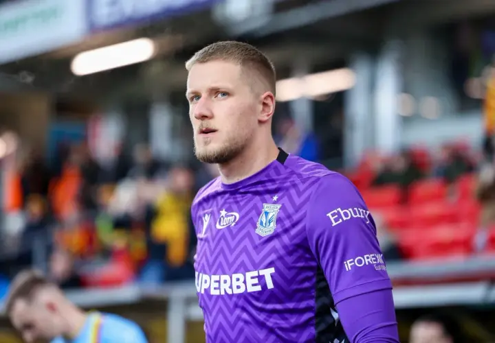 Bartosz Mrozek, bramkarz Lecha Poznań, w fioletowej koszulce z charakterystycznym wzorem.