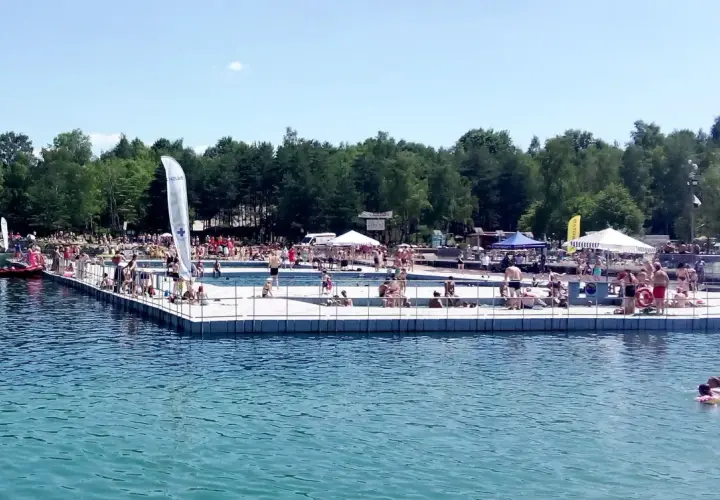 Ludzie odpoczywają i kąpią się na pomoście w Balatonie Trzebinia. Słoneczny dzień zachęca do relaksu nad wodą.