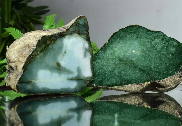 Zwei rohe Jade-Stücke, eines hellblau-grün, das andere tiefgrün. Die Jade-Name-Bedeutung spiegelt sich in ihrer Schönheit wider.