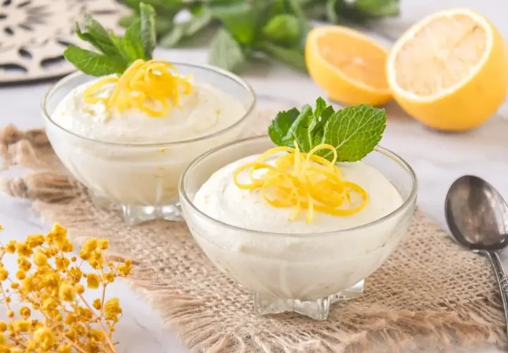 Delicioso mousse de limón con leche condensada, adornado con ralladura de limón y menta fresca.