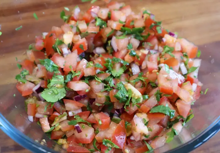 Świeża, kolorowa salsa pomidorowa z cebulą i kolendrą, gotowa do podania.