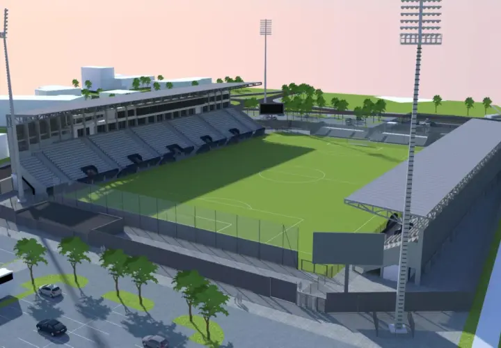 Nowoczesny stadion Sandecji z zieloną murawą, trybunami i oświetleniem.