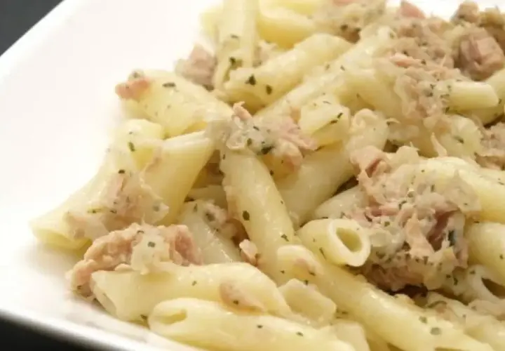 Macarrones con atún, un plato sencillo y delicioso. Pasta penne mezclada con atún desmenuzado y hierbas verdes.