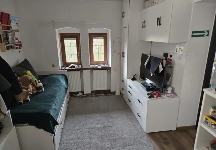 Pokój z łóżkiem, szafami i telewizorem. Idealne miejsce, by zamienię mieszkanie własnościowe na mniejsze.