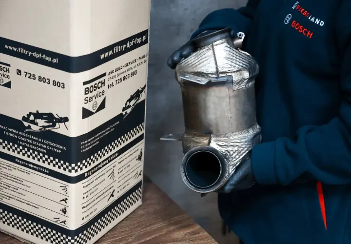 Osoba w rękawiczkach trzyma filtr DPF/FAP obok kartonu z logo Bosch Service.