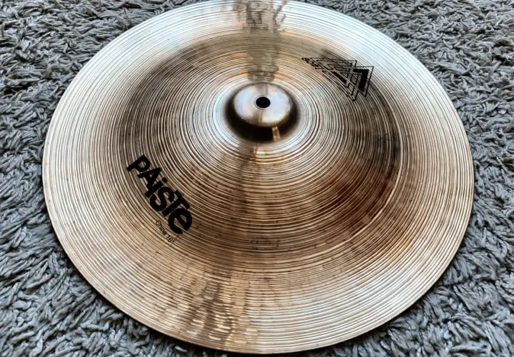 Paiste China 16" - ciche talerze perkusyjne, gotowe do tworzenia unikalnych brzmień na tle szarego dywanu.