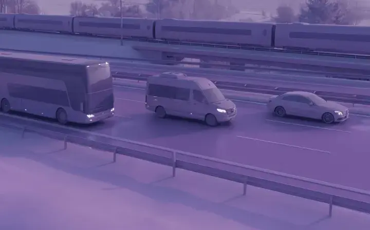 Zastanawiasz się, ile kosztuje bus do Francji? Na drodze widzimy autokar, busa i samochód, a w tle pociąg.