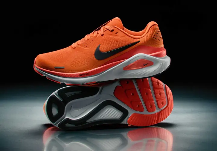 Pomarańczowe obuwie sportowe męskie Nike z czarnym logo. Idealne do biegania, zapewniające komfort i dynamikę.