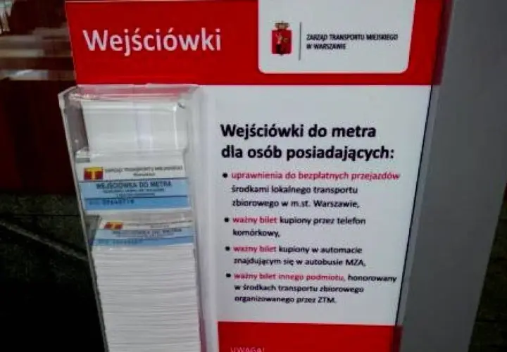 Informacja o tym, jak kupić bilet na metro w Warszawie. Stojak z ulotkami "Wejściówki do metra" i informacją o uprawnieniach.